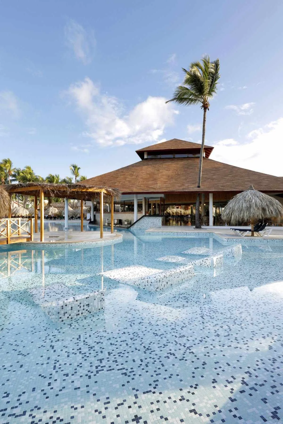 Samana pool area at Grand Palladium Bavaro with palm trees, loungers, and turquoise pool water