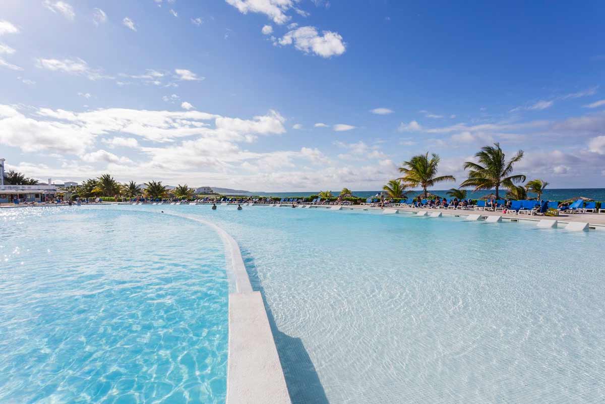 Beachfront view at Grand Palladium Jamaica Resort with Caribbean Sea, beach loungers, umbrellas, and non-motorized water sports area