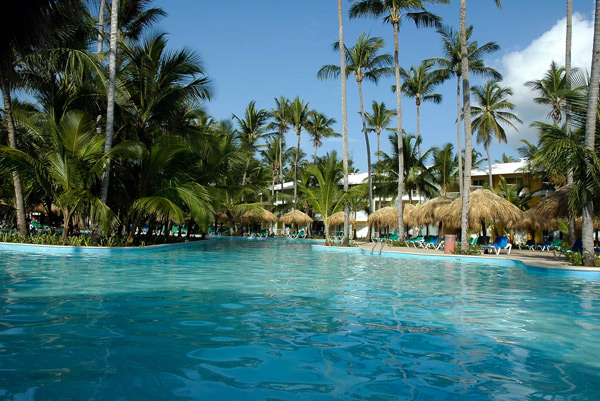 All-inclusive resort experience at Grand Palladium Palace showing the Infinite Indulgence program with dining, pools, and Caribbean lifestyle