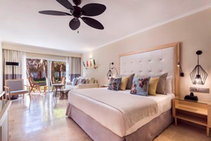 Junior Suite with separate living area, sofa bed, hydro-massage bathtub, and furnished balcony overlooking tropical gardens