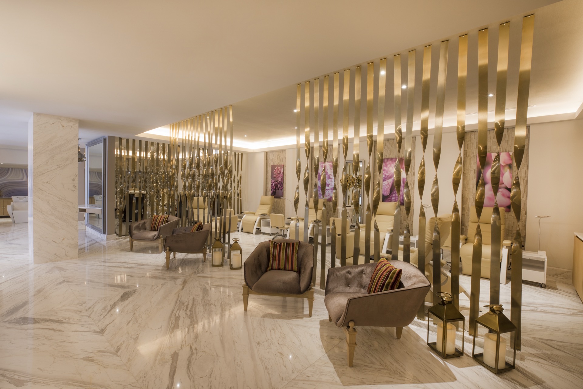 Elegant lobby with gold sculptural partitions, marble floors, and designer furnishings