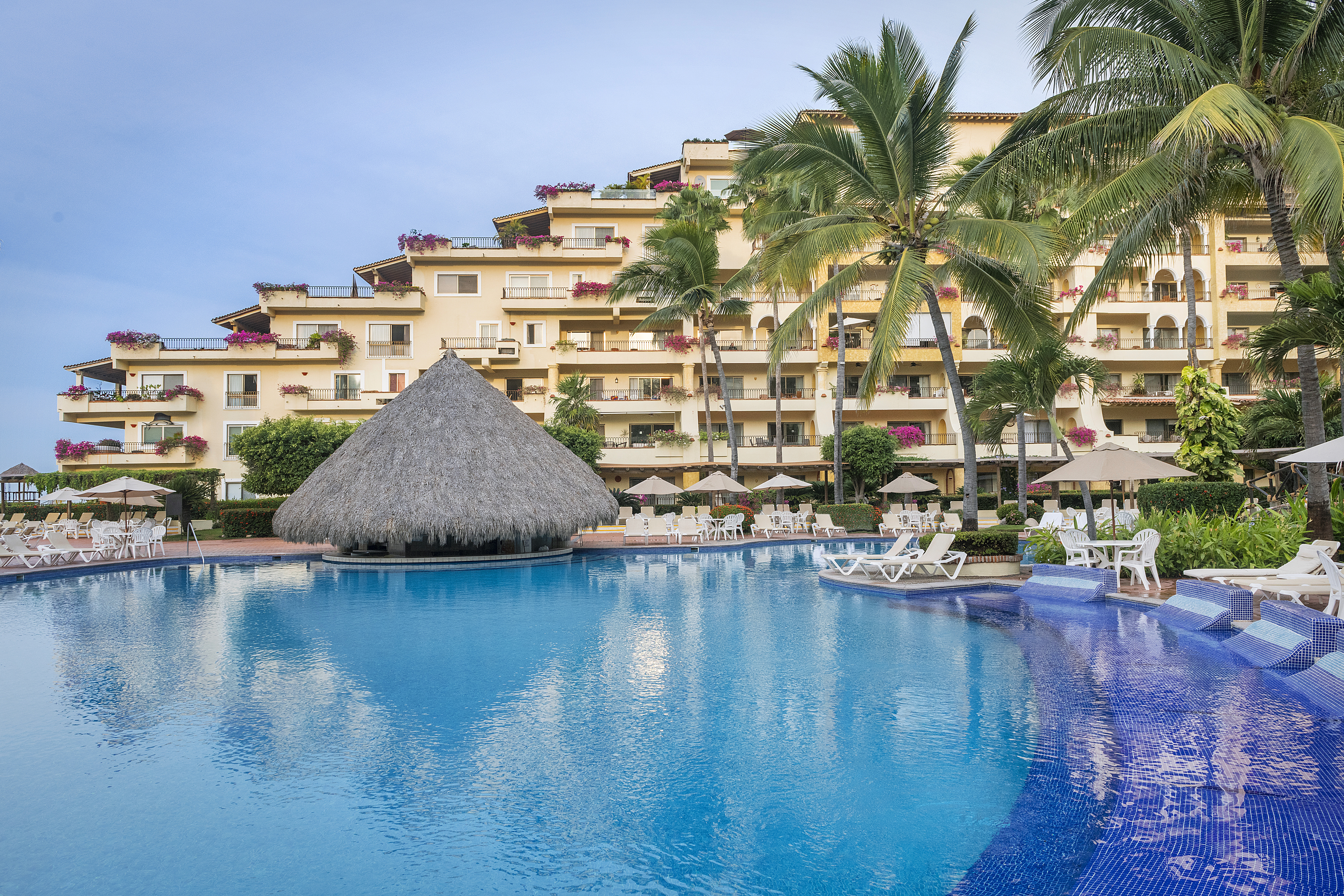 Main pool area with ocean views and palm-fringed lounging deck