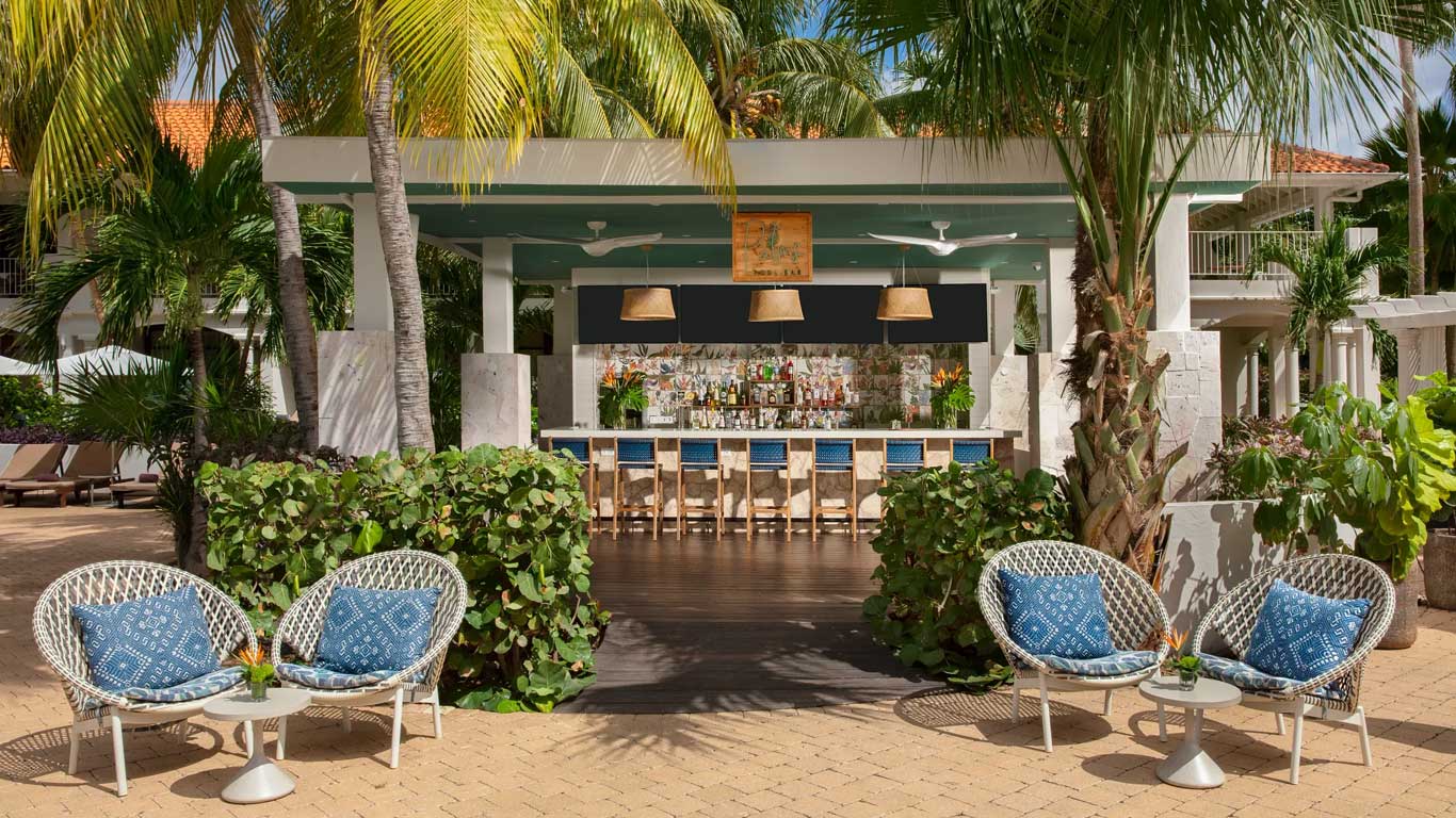 Palms Cocktail Bar with blue-cushioned woven chairs and tropical poolside setting