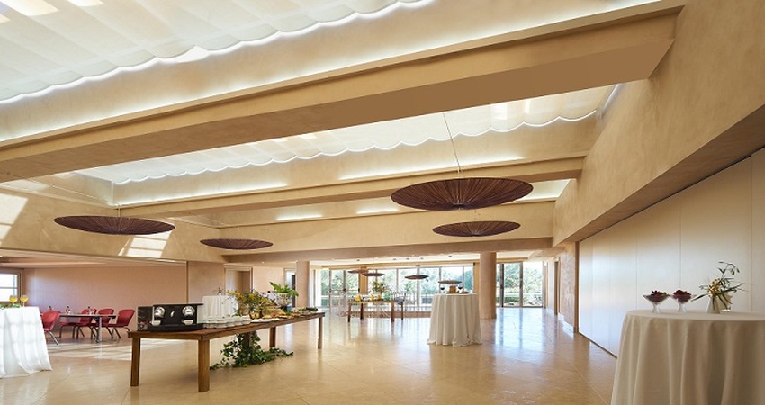 Modern events pavilion with retractable skylight canopies, woven disc pendants, and garden terrace views