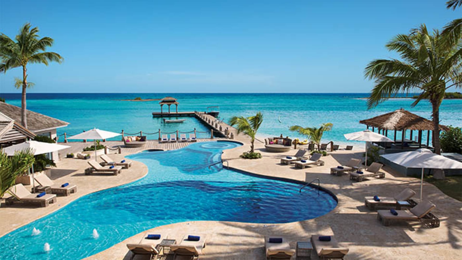 Beachfront infinity pool at Zoetry Montego Bay with pier and ocean views
